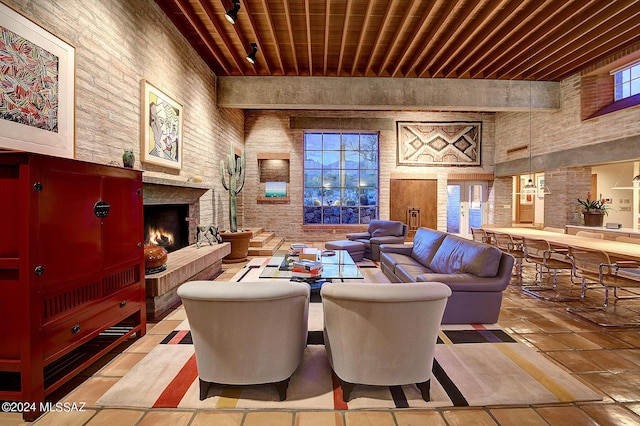 living room with brick wall, a high ceiling, wood ceiling, and beam ceiling