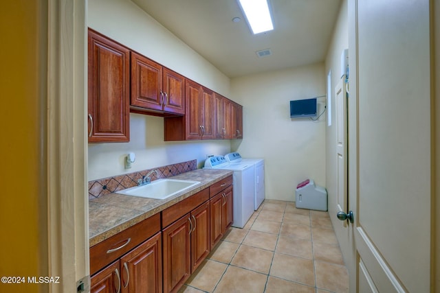 clothes washing area featuring cabinets, separate washer and dryer, sink, and light tile patterned floors