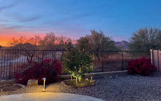 yard at dusk with a mountain view and a patio area