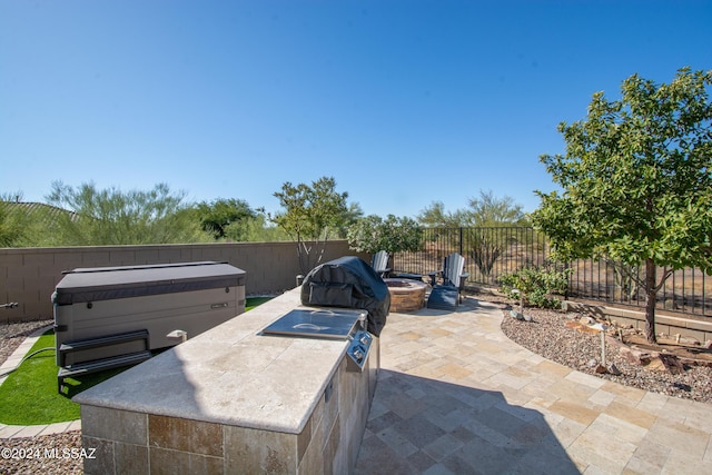 view of patio with grilling area and a fire pit