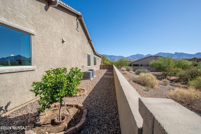 view of side of property with a mountain view and central AC unit