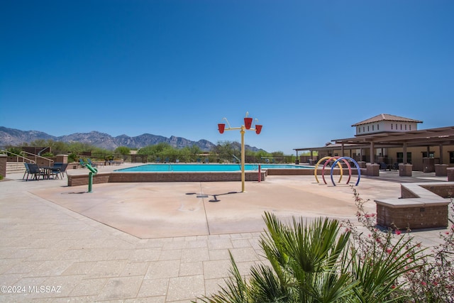 view of home's community with a mountain view, a patio, and a pool