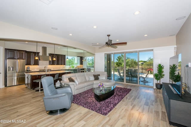 living room with ceiling fan and light hardwood / wood-style floors