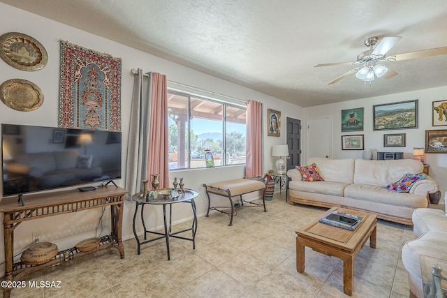 living room with ceiling fan and a textured ceiling