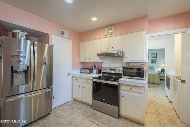 kitchen with light tile patterned flooring, white cabinetry, backsplash, and appliances with stainless steel finishes