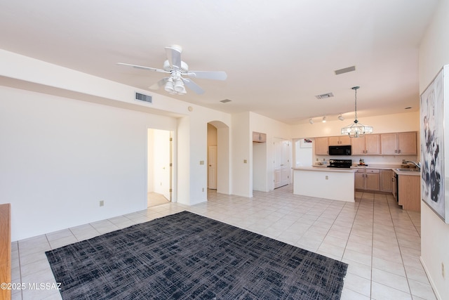 kitchen featuring a center island, light countertops, visible vents, light brown cabinetry, and black microwave