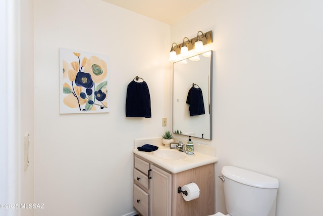 half bath featuring toilet and vanity