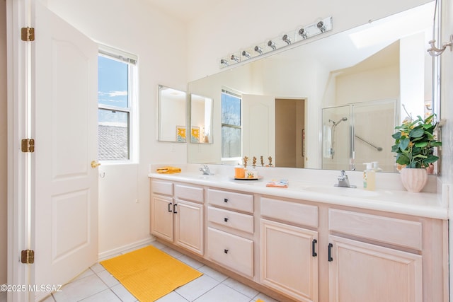 full bath featuring double vanity, a shower stall, a sink, and tile patterned floors