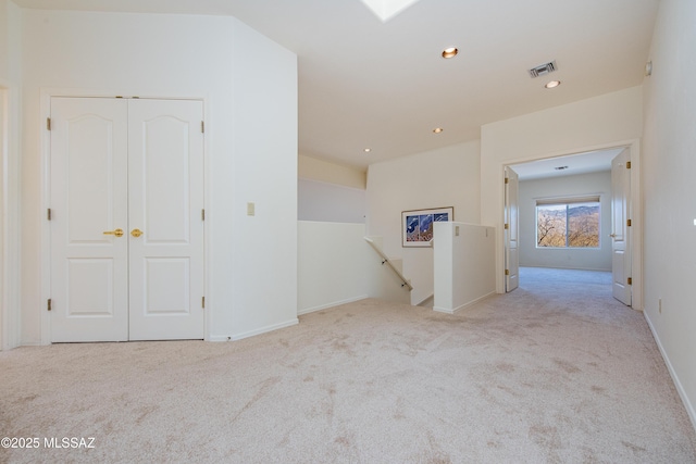 spare room featuring recessed lighting, visible vents, light carpet, and baseboards