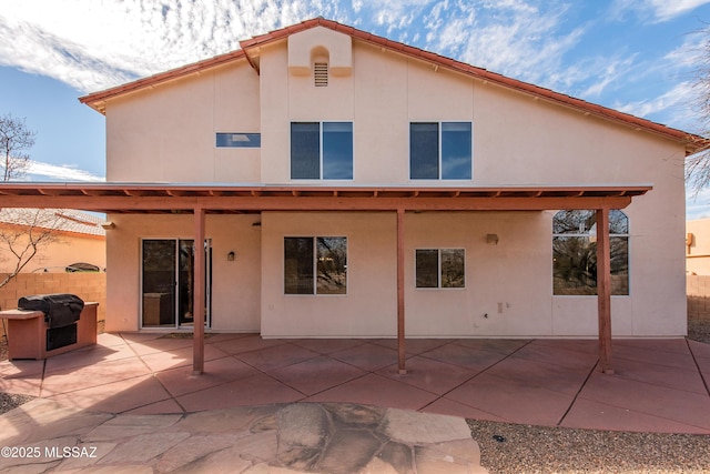 back of property with a patio area and stucco siding