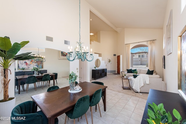 dining space with an inviting chandelier, light tile patterned floors, visible vents, and high vaulted ceiling