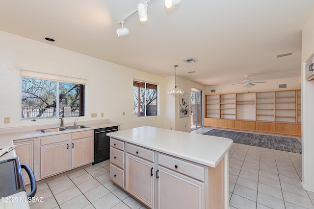 kitchen with light countertops, hanging light fixtures, a kitchen island, a sink, and dishwasher