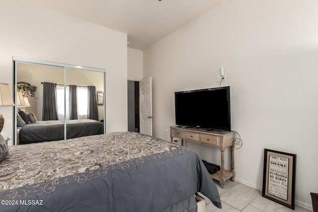 bedroom with vaulted ceiling and a closet