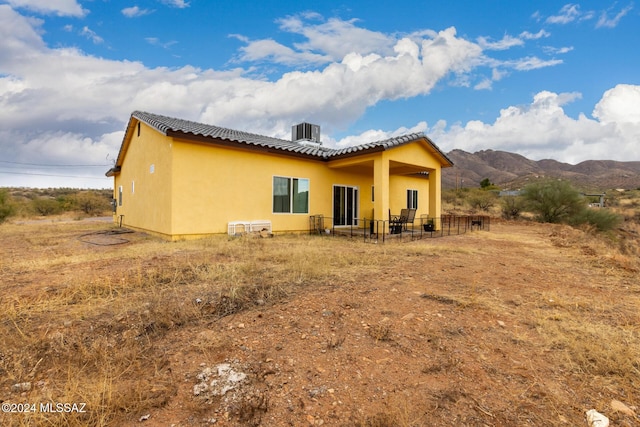 back of house featuring a mountain view and central AC unit