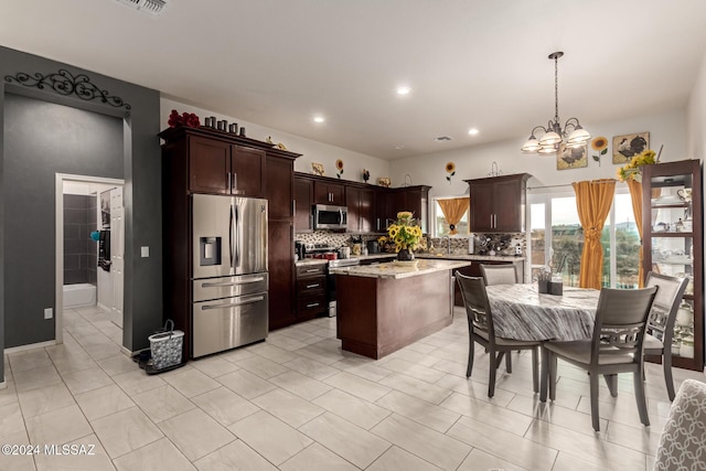 kitchen featuring decorative light fixtures, decorative backsplash, a notable chandelier, dark brown cabinetry, and stainless steel appliances