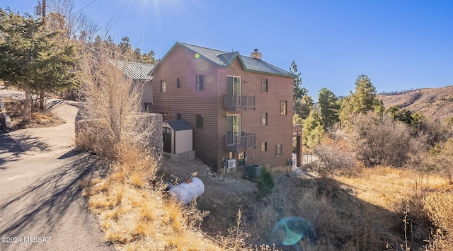 back of house featuring a balcony and central AC