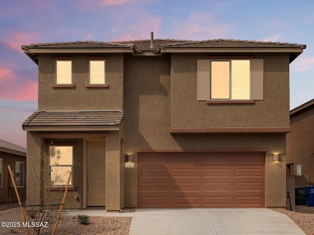 view of front of property featuring a garage, driveway, and stucco siding