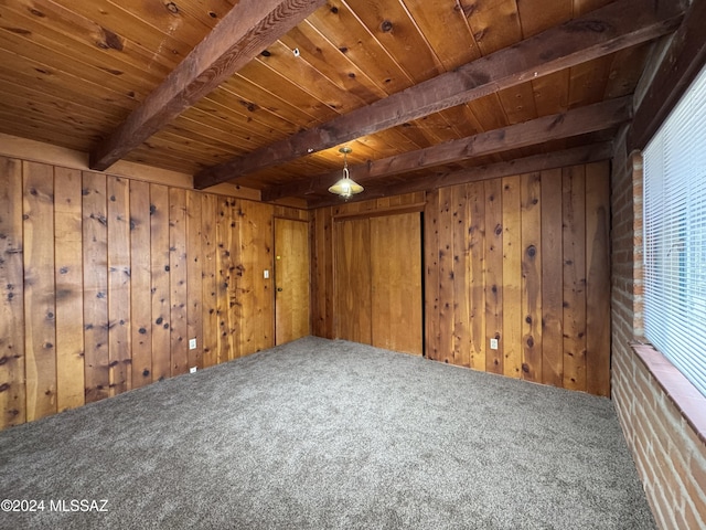 interior space with beamed ceiling, wood walls, and carpet floors