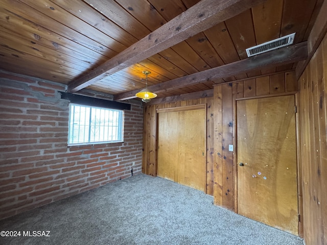 interior space featuring wooden walls, beam ceiling, and brick wall