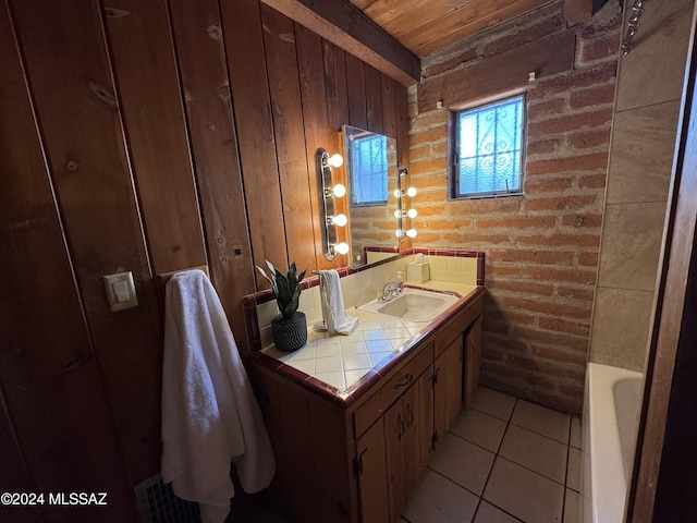 bathroom with a washtub, brick wall, tile patterned floors, wooden walls, and vanity