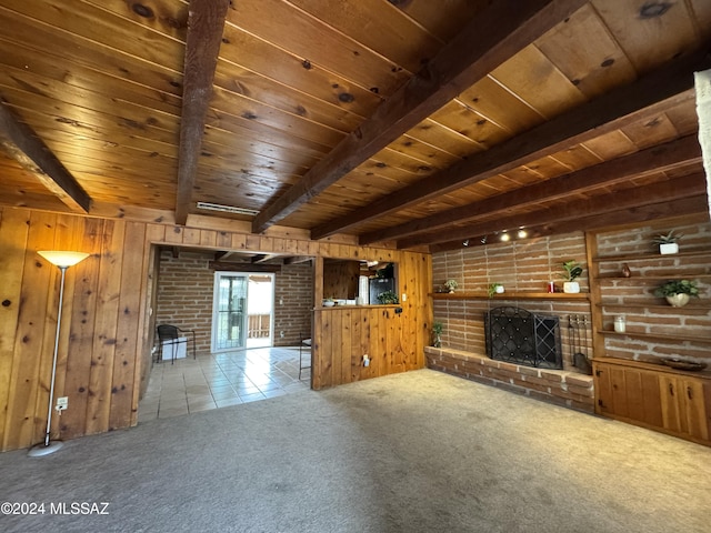 unfurnished living room with beamed ceiling, a fireplace, and wood walls