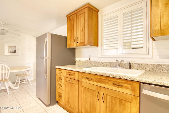 kitchen featuring ceiling fan, sink, lofted ceiling, light tile patterned floors, and appliances with stainless steel finishes