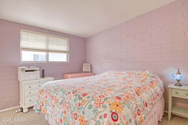 carpeted bedroom featuring brick wall