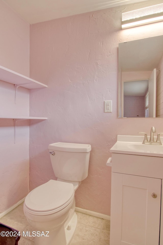 bathroom featuring tile patterned flooring, vanity, and toilet