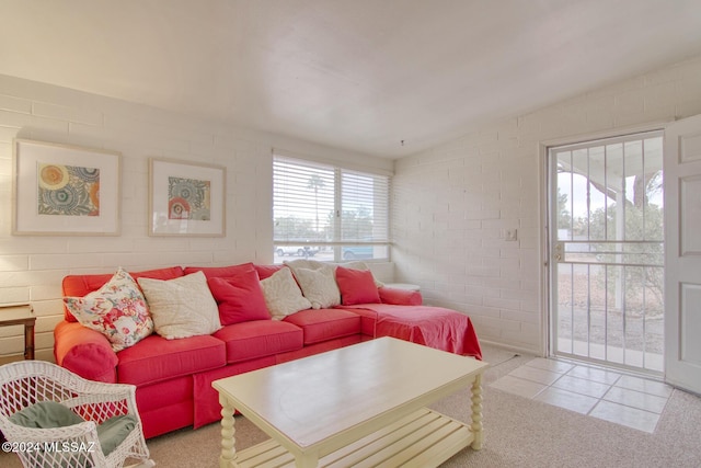 living room with light tile patterned flooring and brick wall