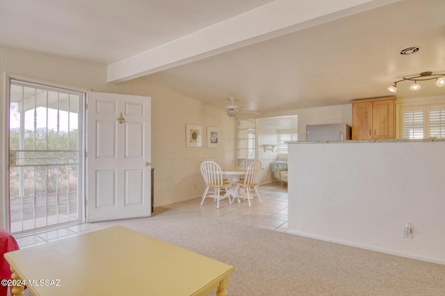 carpeted foyer featuring vaulted ceiling with beams and ceiling fan