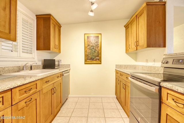 kitchen with sink, light tile patterned flooring, stainless steel appliances, and rail lighting