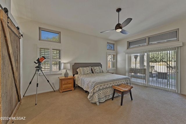 bedroom featuring carpet flooring, a barn door, multiple windows, and ceiling fan