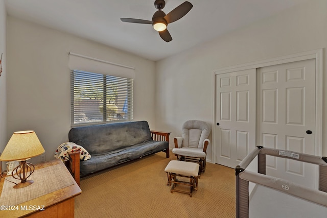 sitting room with ceiling fan and carpet