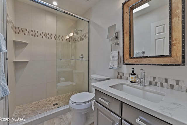 bathroom featuring vanity, toilet, and a shower with door