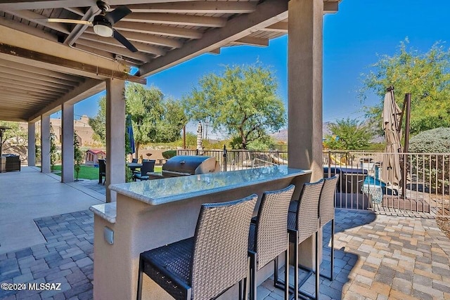 view of patio / terrace featuring ceiling fan and an outdoor bar