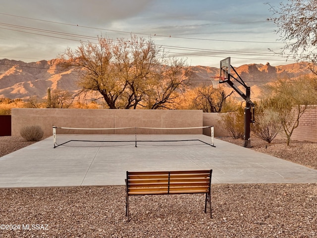 surrounding community with basketball hoop, a mountain view, and tennis court