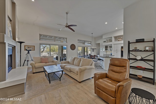 living room with light hardwood / wood-style floors, ceiling fan, and sink