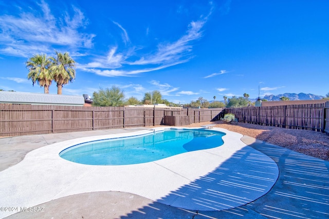 view of swimming pool with a mountain view and a patio area