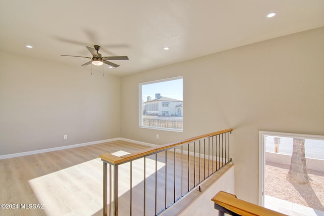 stairs featuring ceiling fan and hardwood / wood-style floors