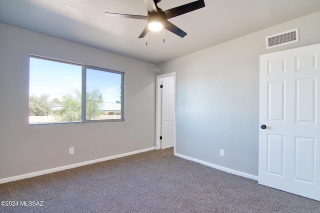 carpeted spare room with ceiling fan