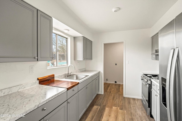 kitchen featuring gray cabinetry, sink, dark hardwood / wood-style flooring, and appliances with stainless steel finishes