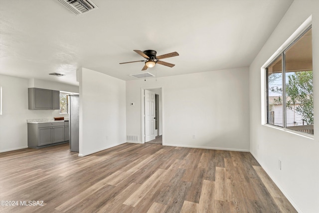 empty room with hardwood / wood-style floors and ceiling fan