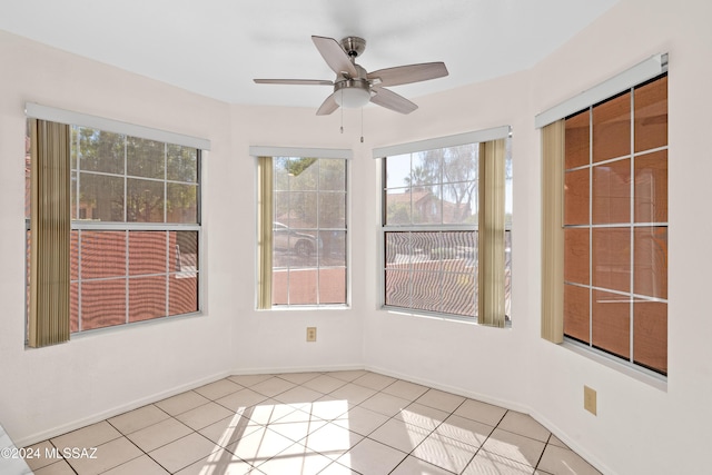 unfurnished sunroom with ceiling fan