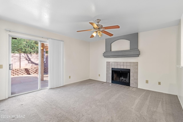 unfurnished living room featuring ceiling fan, light carpet, and a tile fireplace