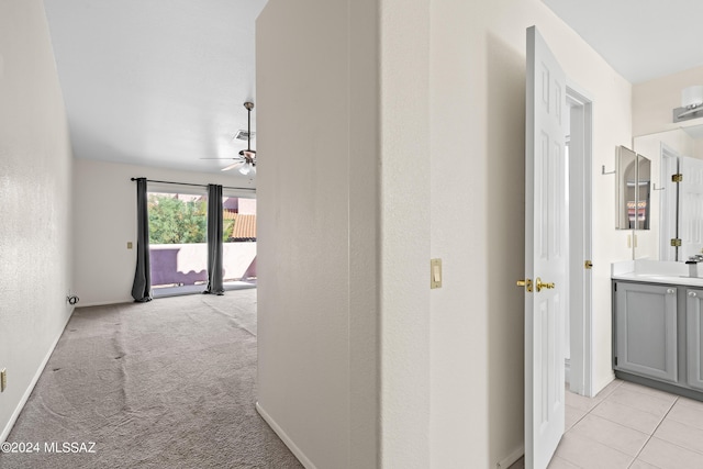 corridor featuring light colored carpet and sink