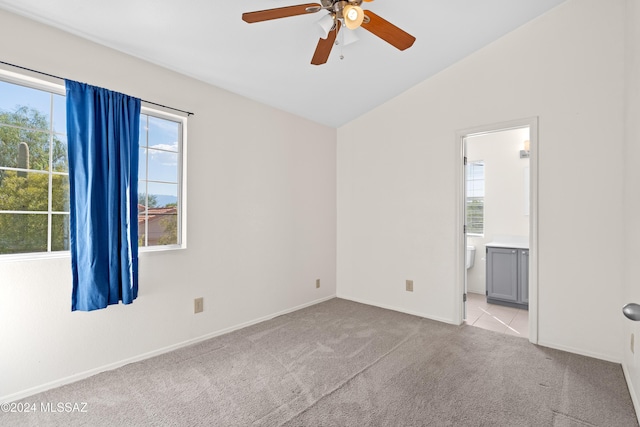 carpeted spare room with ceiling fan and vaulted ceiling