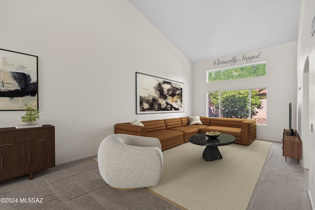 living room with light carpet and high vaulted ceiling