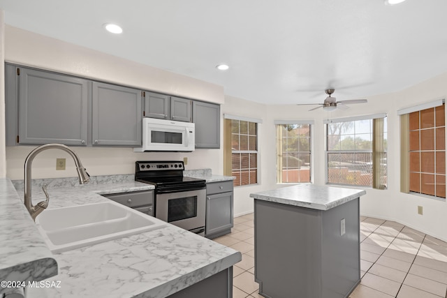 kitchen featuring gray cabinets, electric range, and a kitchen island