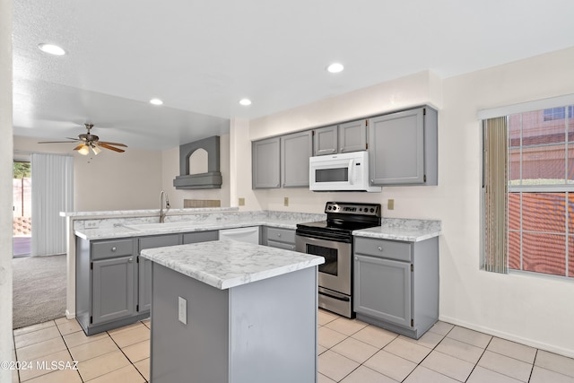 kitchen with gray cabinets, a kitchen island, white appliances, and sink