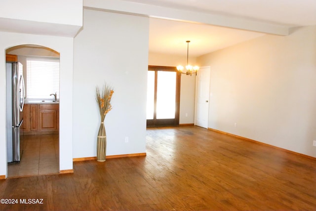 unfurnished room with beamed ceiling, sink, dark wood-type flooring, and a chandelier